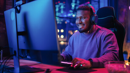 Gaming at Home: Portrait of a Happy African American Gamer Playing a Round in Online Video Game on Computer. Professional Stylish Male Player Enjoying Online Multiplayer PvP Tournament. Static Shot.