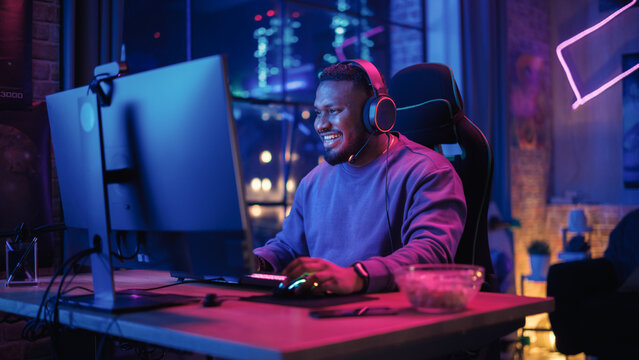 Gaming at Home: Portrait of a Happy African American Gamer Winning a Round in Online Video Game on Personal Computer. Professional Stylish Male Player Enjoying Online Multiplayer PvP Tournament.