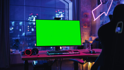 Gaming at Home: Empty Gaming Station with Player's Personal Computer with Green Screen Chroma Key Display Standing on a Wooden Desk in Stylish Loft Apartment with Neon Lights.  © Gorodenkoff