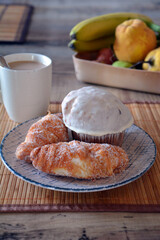 Homemade croissants and muffin decorated with white chocolate. Sweet breakfast.