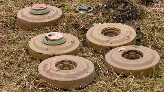 Anti-tank mines lie on dry grass on the ground. The Russian army mines the occupied territories in Ukraine. Russo-Ukrainian War 2022