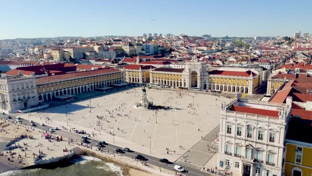 Lisbon - Portugal. View of city center with famouse Commerce Square and Arco da Rua Augusta. Drone ascending and rotating right. Plane on sky flying over the city. Famous touristic travel destination.