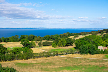 Fototapeta na wymiar View point from the hike around Kullabeg, Sweden. View over the golf course of Mölle, the sea in the background and Bjärehalvön even further away. Trees on golf course next to hike and sea