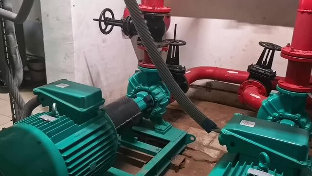 Two large electric pumps on the heating pipe in the boiler room.