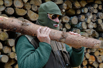 A masked man steals firewood in the forest. Rising energy prices, fears of gas shortages and...