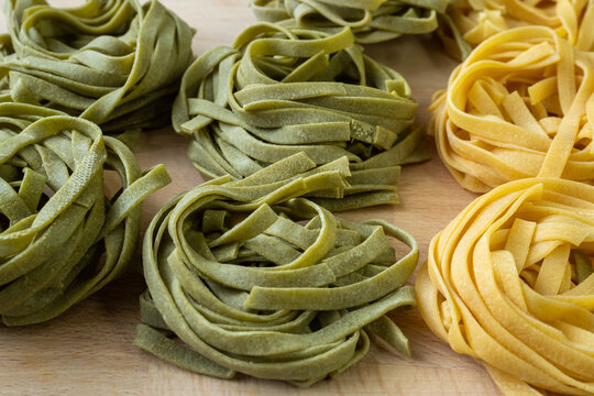 Fresh homemade green and yellow pasta tagliatelle. Raw homemade spinach pasta. - Powered by Adobe