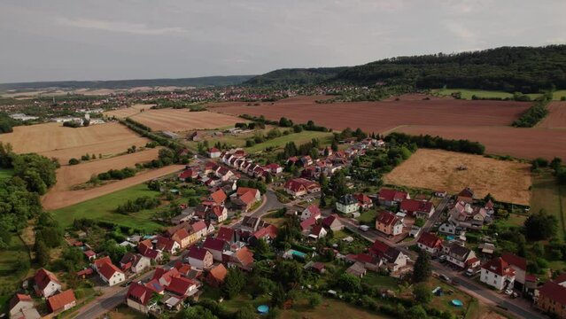 Aer ial view of a German village surrounded by meadows, farmland and forest in Germany.