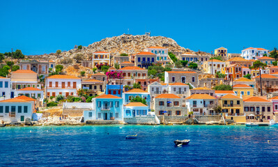Fototapeta na wymiar Colorful houses in picturesque small island Halki in Greece