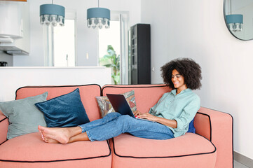 Full length view of the black female businesswoman or female freelancer in comfy casual clothes...