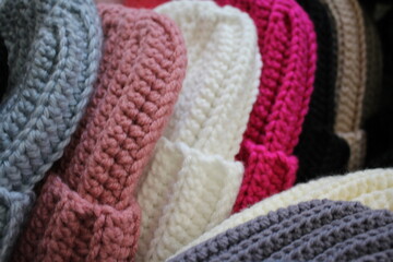 Hats crocheted knitted in the hands of a girlon the street. Product listing for sale. Urban style. Fashion. Autumn