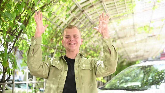 Caucasian young man showing applause in sign language. 