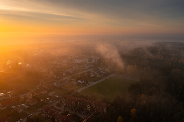 Morning fog over the forest and buildings in northern Poland