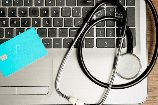 top shot of a stethoscope on a laptop and a credit card. Concept of the economic cost of healthcare - Powered by Adobe