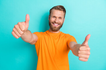 Portrait of handsome good mood guy with blond beard wear orange t-shirt showing thumbs up nice job...