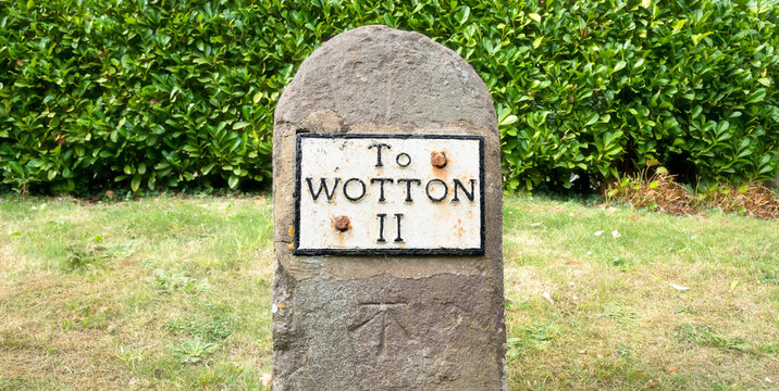 Old Roadside Wotton (under Edge) mileage sign with benchmark, United Kingdom