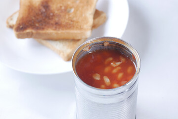 close up of preserved beans in a tin container on white 