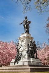 Bronze statue of Revolutionary War hero Marquis de Lafayette at Lafayette Square in Washington DC by sculptor Alexandre Falguiere in 1891 during cherry blossom season
