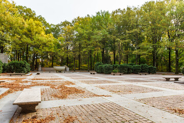 Stone plaza with benches covered in leaves in autumn at the memorial for 26th President Theodore Roosevelt at Theodore Roosevelt Island in Washington, DC - obrazy, fototapety, plakaty