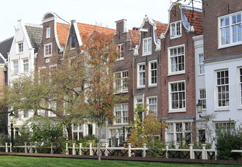 Fototapeta na wymiar Amsterdam Begijnhof Courtyard Traditional Brick House Facades with Autumn Trees, Netherlands