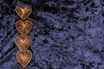 Christmas concept. On a purple velvet background, Christmas toys in the form of hearts with a place for text. Postcard for the new year.