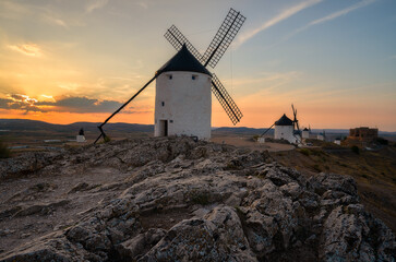 Old windmills at sunset in Consuegra - obrazy, fototapety, plakaty