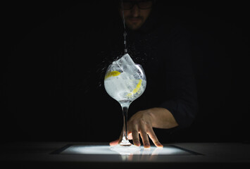 Waiter preparing a spirit drink on a black background