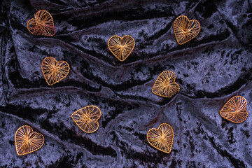 Christmas concept. On a purple velvet background, Christmas toys in the form of hearts with a place for text. Postcard for the new year.