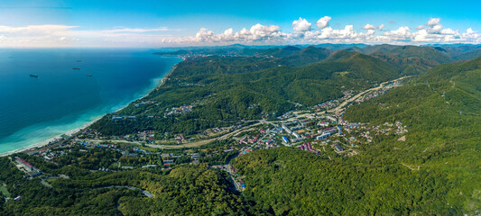 Fototapeta na wymiar aerial panorama view of the resort village of Shepsi near the Black Sea coast surrounded by forested mountains of the Caucasus on a sunny summer day