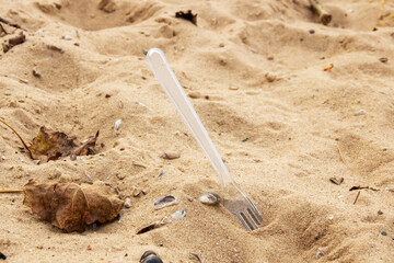 Plastic fork in the sand on the beach