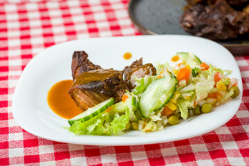 pieces of roasted pork meat and  vegetable salad