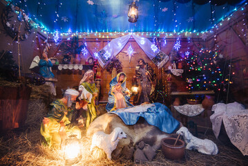 Obraz na płótnie Canvas Christmas crib at a Cologne Christmas market. The scene where the Virgin Mary gave birth to Jesus and he lies in the cradle surrounded by people who have come to celebrate the Nativity of Christ
