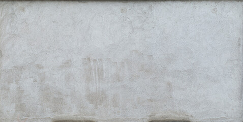 Front view of a plastered gray stone wall with stains from graffiti removal. Abstract high resolution full frame textured background.
