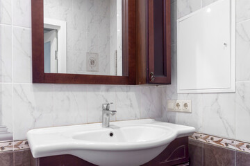 Classic modern white washbasins with chrome water tap and mirror. White sink object in contemporary hotel or house bathroom