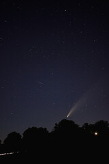 landscape of the night sky, a comet neowise flies over the earth