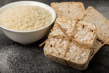 Round rice cakes and rice in a bowl on a  black table. Crispbread.Puffed rice bread. diet crispy round rice cakes.Place for text. Place for copy. Healthy food. dietary product