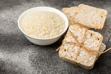 Round rice cakes and rice in a bowl on a  black table. Crispbread.Puffed rice bread. diet crispy round rice cakes.Place for text. Place for copy. Healthy food. dietary product
