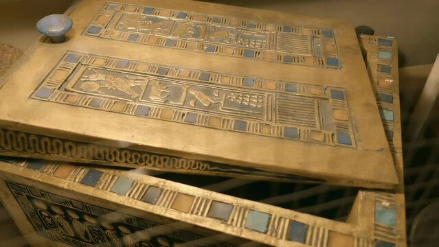 A wooden jewelry box covered with hieroglyphs, signs, symbols and images - one of the exhibits of the tomb of Tutankhamen, a symbol of Ancient Egypt. Shot in motion. Closeup