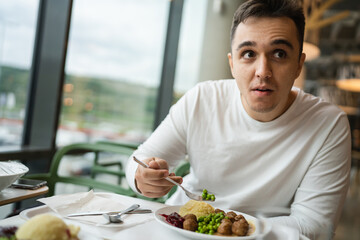 One man young adult caucasian male sitting at restaurant eat