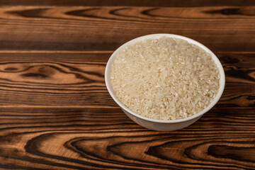 Healthy food. A bowl of steamed rice on a brown marble background. Place for text, copy space. Diet porridge.