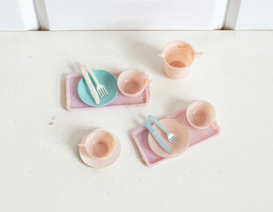 Miniature plastic kitchen utensils for a dollhouse - breakfast trays, plate and cups
