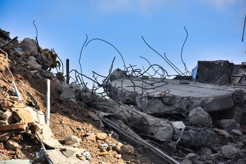The destroyed walls of the house with protruding fittings. Destroyed building, can be used as demolition, earthquake, bomb, terrorist attack or natural disaster concept. 