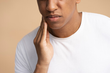 Portrait of unhealthy man pressing sore cheek, suffering acute toothache, periodontal disease