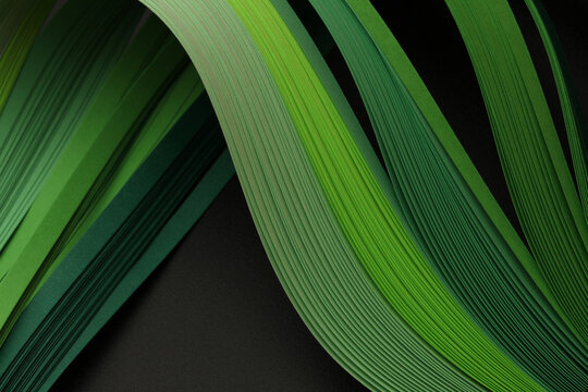 Green neon color strip wave paper on black. Abstract texture copy space background.
