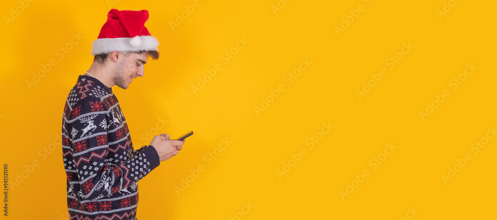 Poster isolated young man with santa claus hat and mobile phone