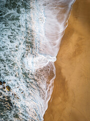 Aerial views of crashing waves at the beach