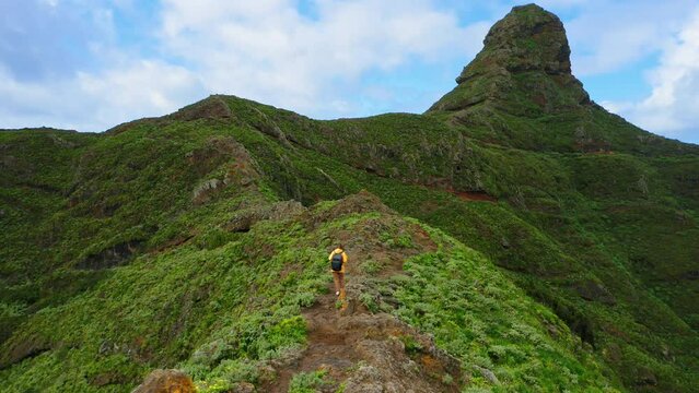 Roque path Taborno. Aerial drone flight over green mountains. Tourist woman walk hike, trail. Nature landscape. Solo travel. Tenerife Canary Island Spain. Mirador Fuente del Lomo.