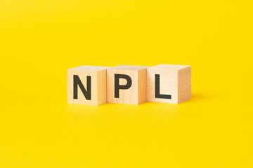 technical term of npl on wooden cubes on yellow background, non performing loans