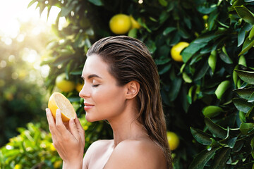 Beautiful woman with smooth skin with a lemon fruit in her hands - Powered by Adobe