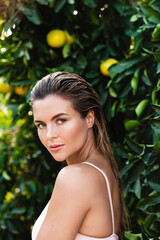 Portrait of beautiful woman with smooth skin against lemon trees