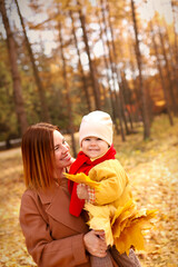  Mother and daughter having fun in autumn park. Happy family on walk. High quality photo